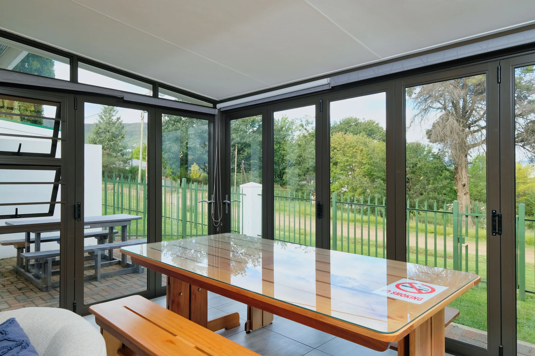 Bright modern sunroom enclosed with dark aluminum framed glass