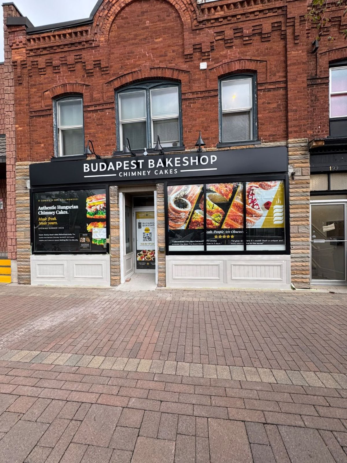 Brick-front bakery storefront with black-framed display windows and entry door