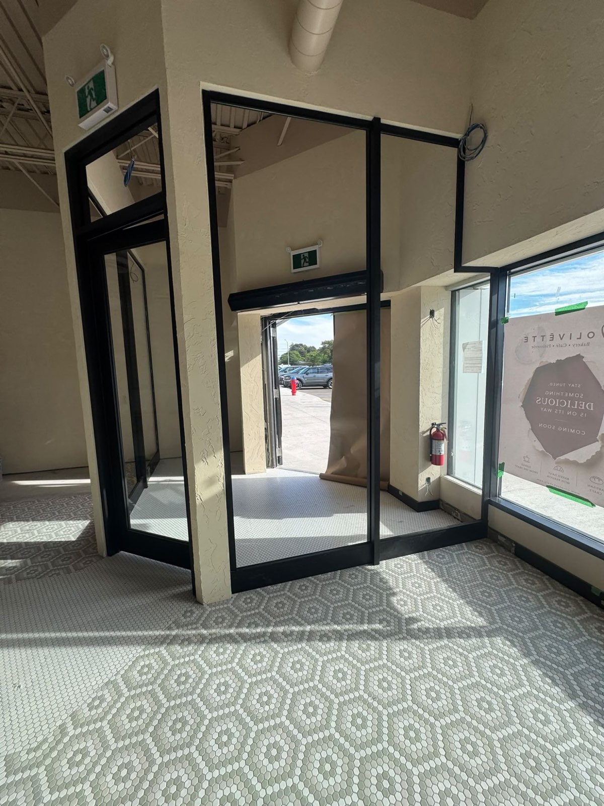 Interior entry vestibule framed in black aluminum and glass
