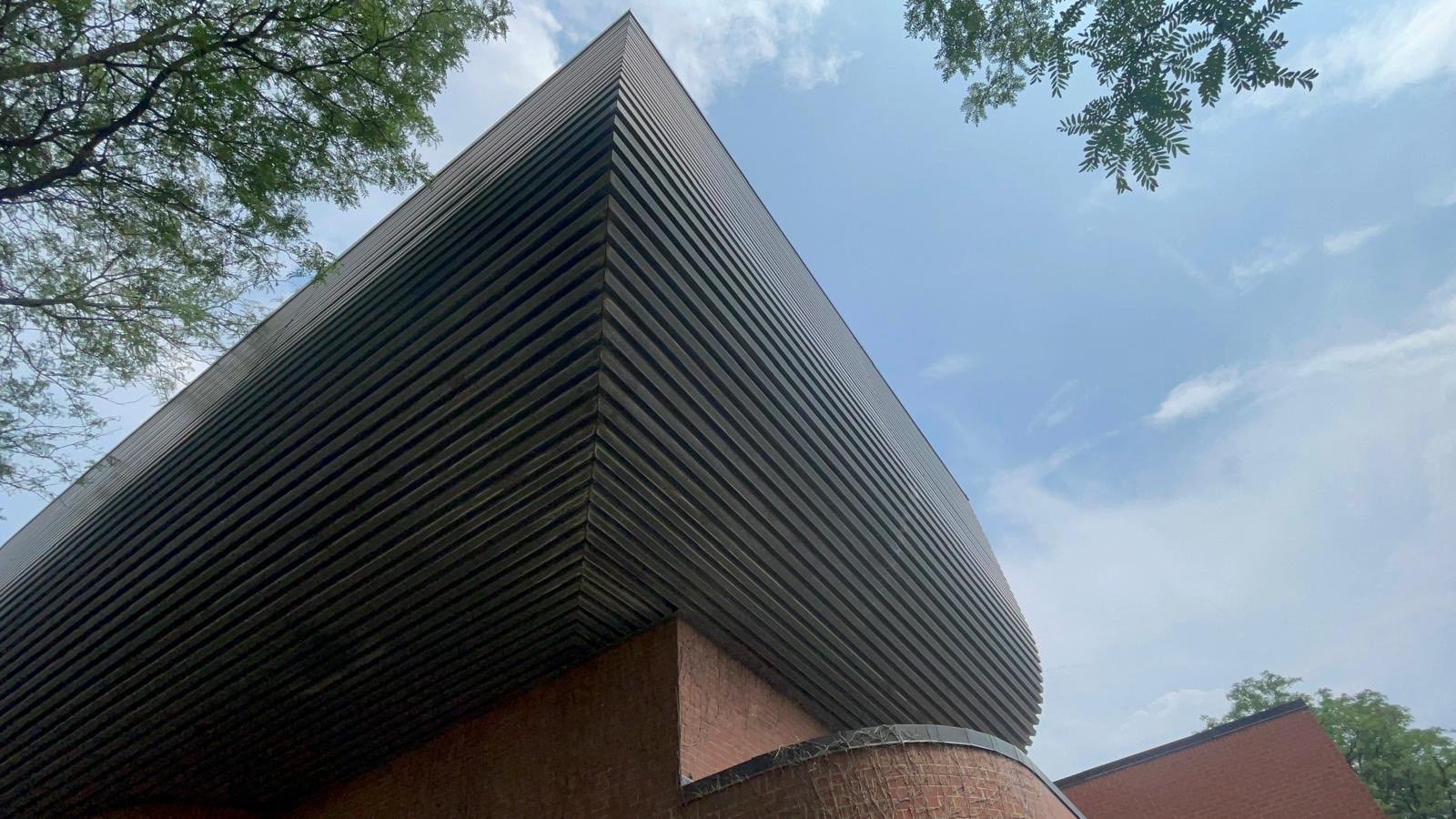 Curved dark metal canopy edge against the sky