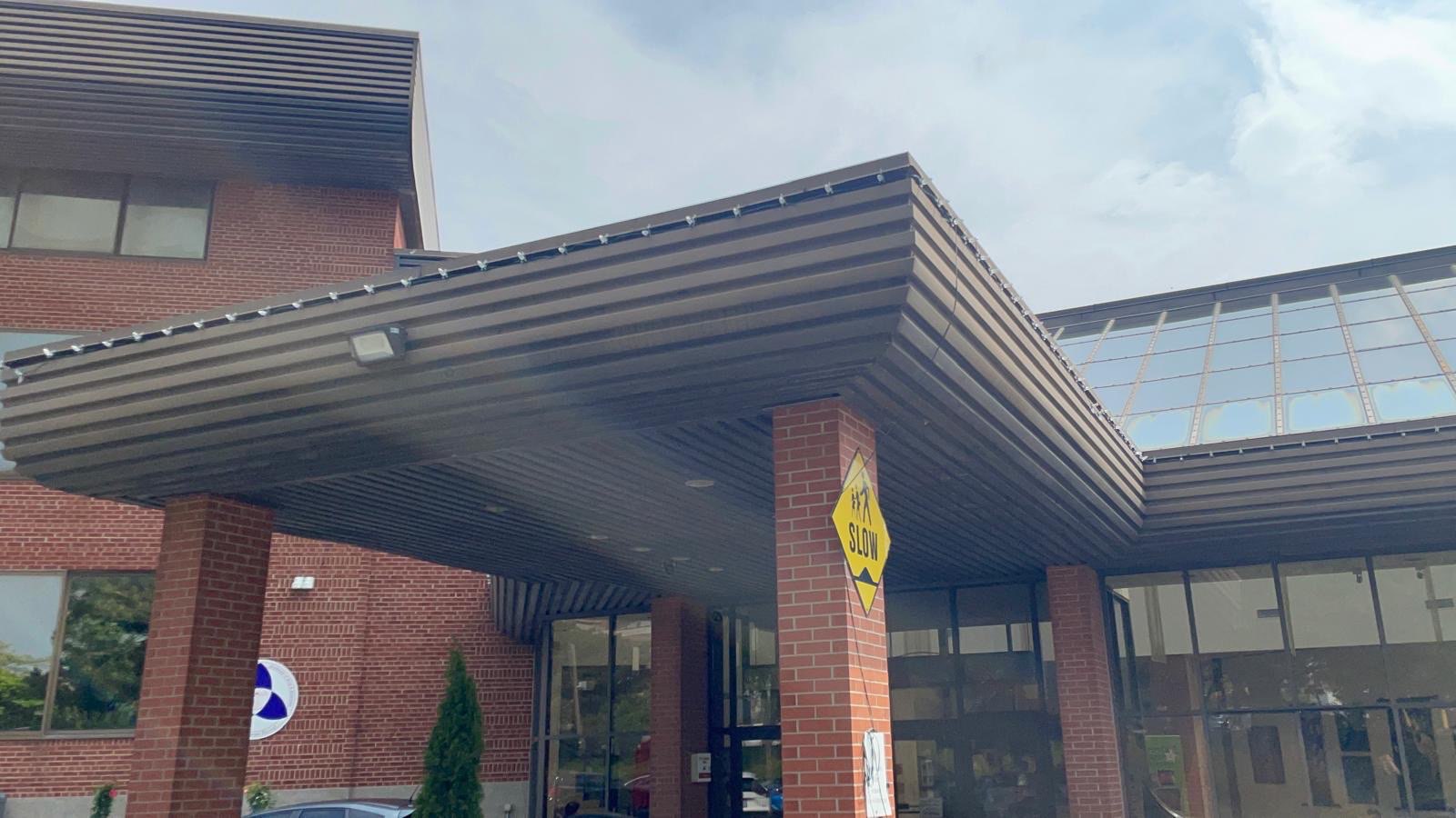 Dark metal entrance canopy on a brick commercial building