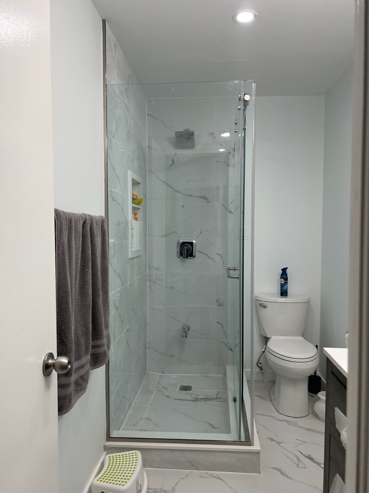 Frameless glass shower door in a narrow bathroom