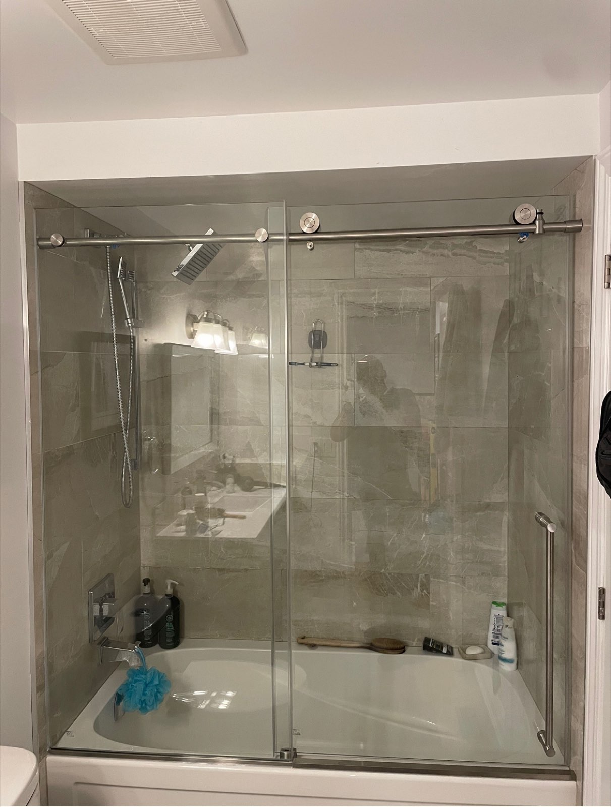 Glass shower enclosure with marble-look tile