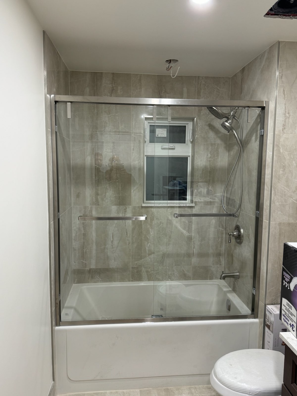 Framed sliding glass doors on a bathtub under a window