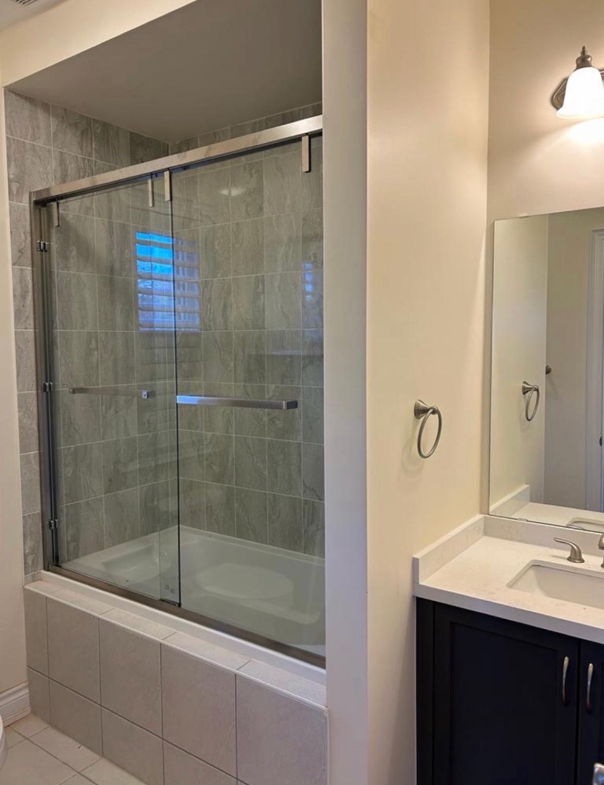 Sliding glass bathtub doors next to a vanity
