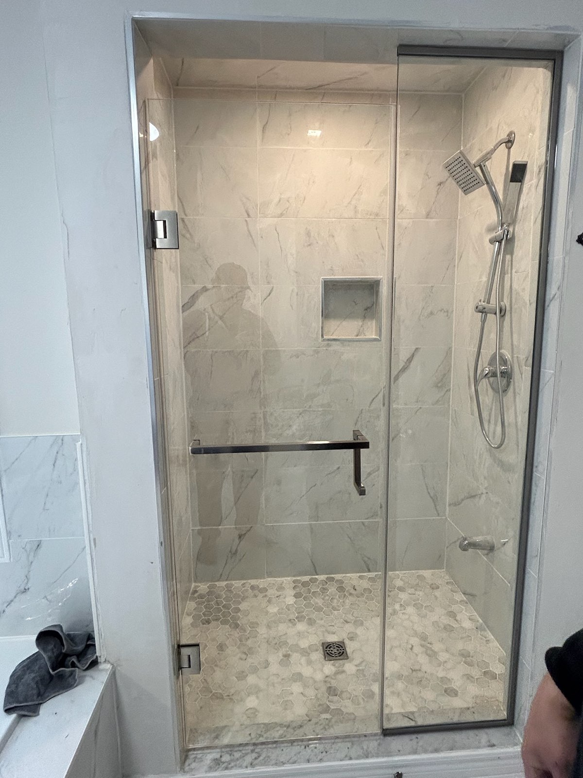 Frameless glass shower door on a tiled walk-in shower