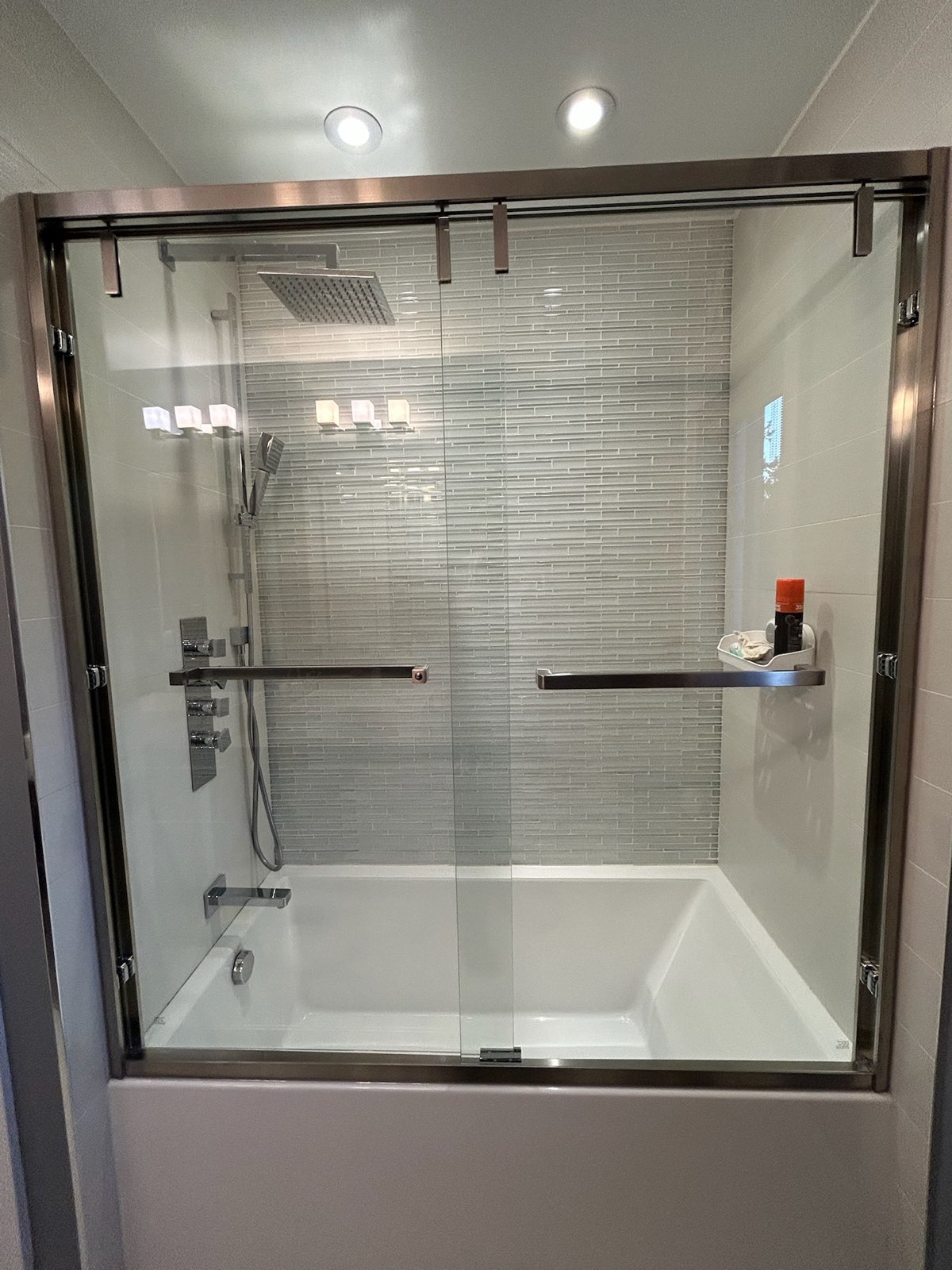 Sliding glass bathtub doors with a bronze-coloured frame