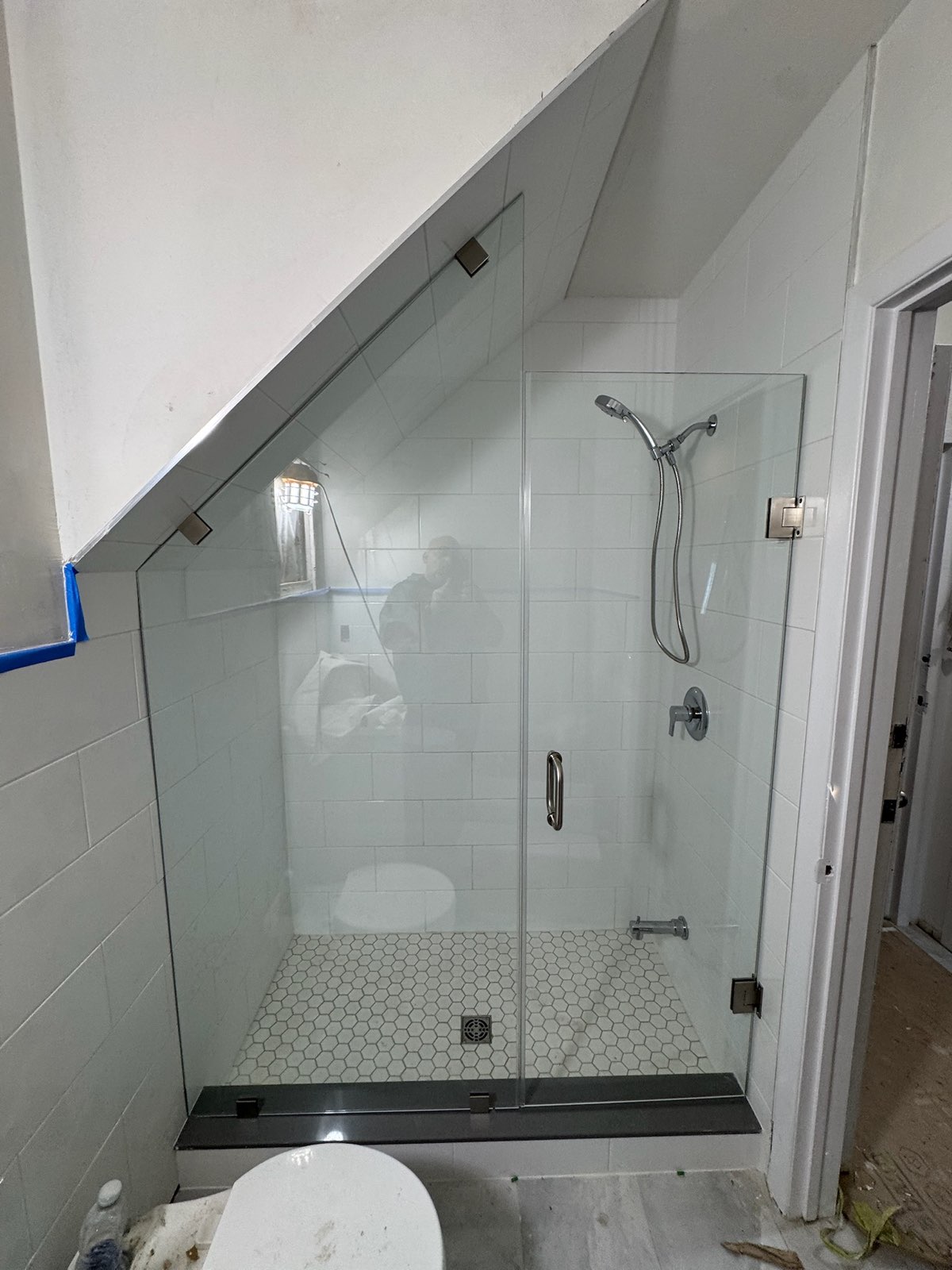 Frameless glass shower fitted under a sloped ceiling