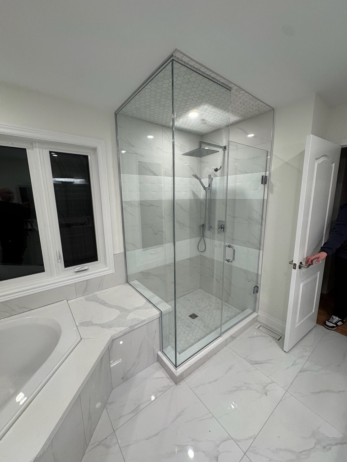 Corner frameless glass shower in a white bathroom