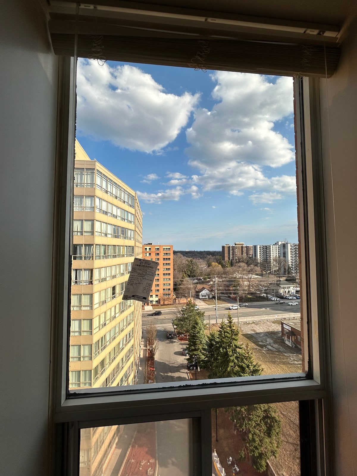 Large window in a high-rise unit with a view over the city
